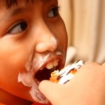 Photo of a child eating a cupcake