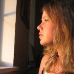 Photo of a teenage girl looking out the window