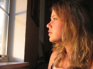 Photo of a teenage girl looking out the window
