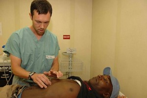 Photo of a doctor preforming acupuncutre aboard a US Navy vessel