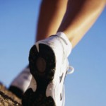 Photo of feet walking against blue sky backdrop