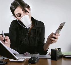 Photo of a woman multitasking at her desk