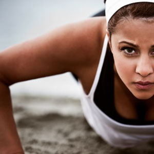 Photo of a woman doing push-ups on the beach