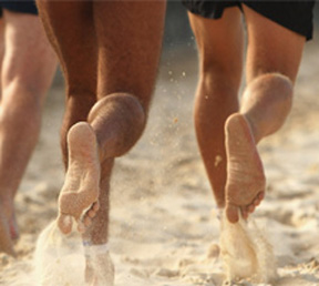 Photo of bare feet running on the sand