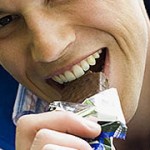 Close up photo of a man eating chocolate