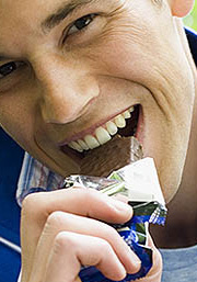 Close up photo of a man eating chocolate