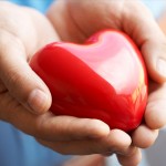 Photo of two hands wrapped around a heart shape