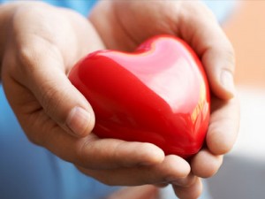 Photo of two hands wrapped around a heart shape