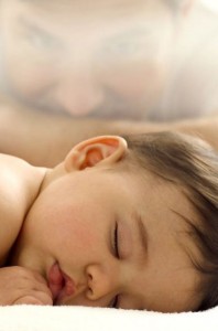 Photo of a baby boy sleeping with father in the background