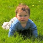 Photo of a child crawling in the grass