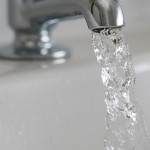 Close up photo of water comoing out of a tap