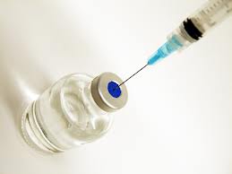 Photo of a needle drawing medicine from a bottle
