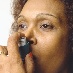 Photo of a woman using an asthma inhaler