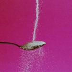 Photo of sugar pouring over a spoon