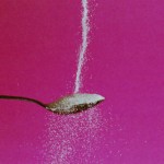 Photo of sugar pouring over a spoon