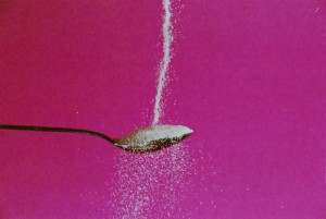 Photo of sugar pouring over a spoon