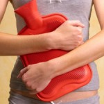 Photo of a woman holding a hot water bottle over her stomach