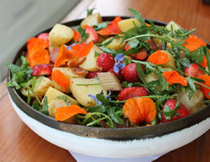 Photo of a potato salad with strawberries, bitter herbs and nasturtiums