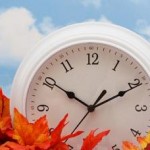 Photo of a clock sitting in autumn leaves