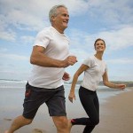 Photo of a man and a woman runnign on a beach