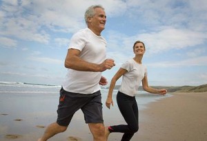 Photo of a man and a woman runnign on a beach