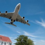 Photo of a jet aircraft flying over a house