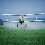 Photo of a airplane spraying pesticides on a field