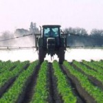 Photo of a field being sprayed with pesticides