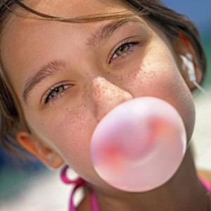 Photo of a girl chewing gum and blowing a bubble