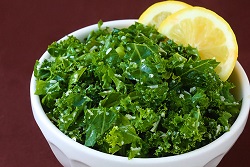 Photo of a bowl of kale with a lemon slice