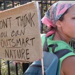 Photo of a woman carrying an anti-GMO protest sign on her back