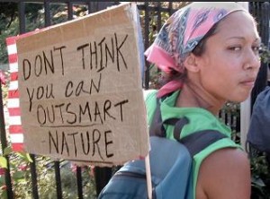 Photo of a woman carrying an anti-GMO protest sign on her back