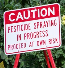 Photo of a sign warning of pesticide spraying