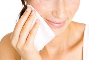 Photo of a woman using a facial wipe