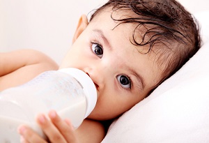 Photo of an infant drinking from a bottle