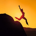 Photo of a woman leaping from a rock