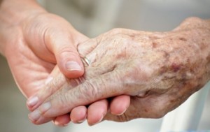 Photo of a young hand holding an older hand