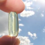 Photo of fingers holding a vitamin D capsule