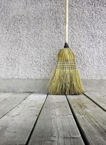 Photo of a broom on bare floorboards