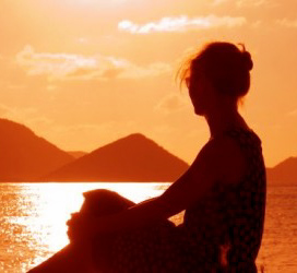 Photo of a woman watching a sunset