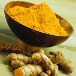 Photo of a bowl and root of turmeric