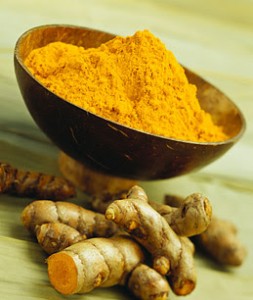 Photo of a bowl and root of turmeric