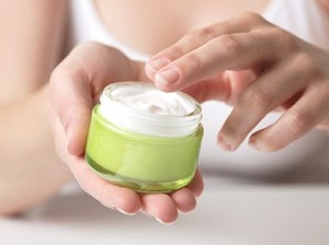 Photo of woman using face cream