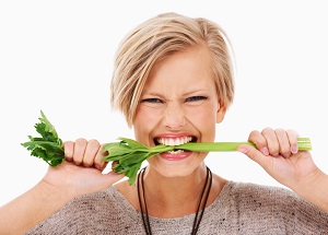 photo of a woman biting a celery stick